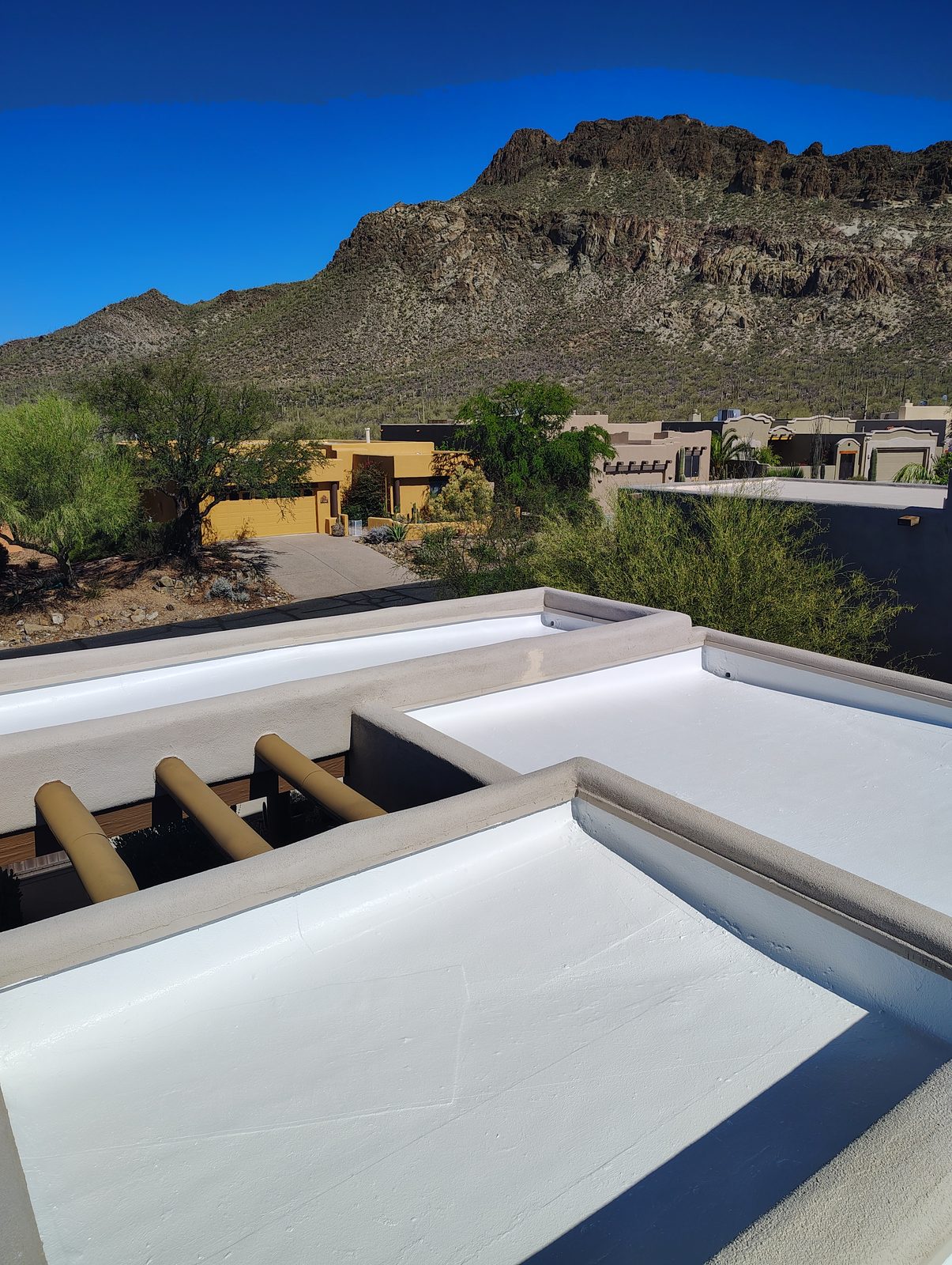 Coated white flat roof overlooking desert homes and mountain ridges in the Tucson foothills