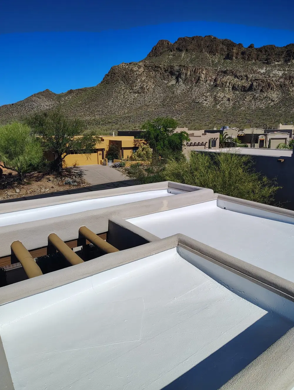 Coated white roof overlooking desert homes and mountain ridges in the Tucson foothills