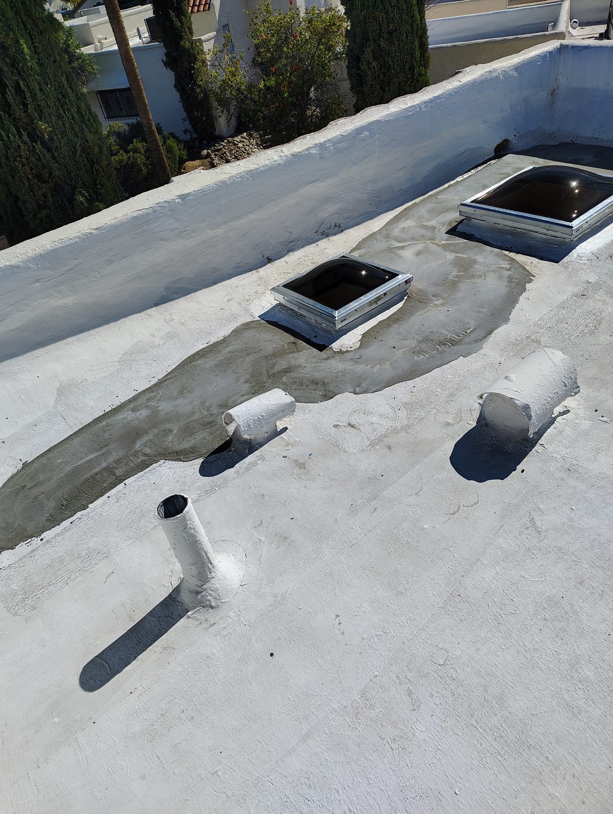 Flat roof repair work around vents and skylight curbs on a Tucson home