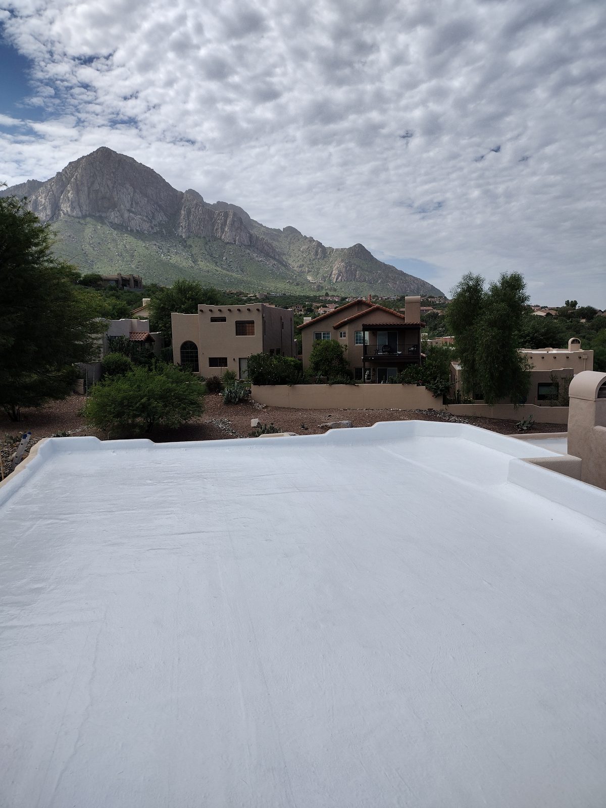 White elastomeric roof coating on a flat roof below Pusch Ridge in the Tucson foothills