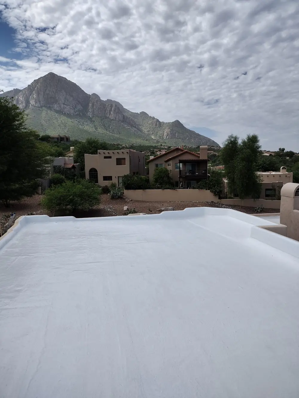 White premium-grade acrylic roof coating on an Oro Valley home below Pusch Ridge