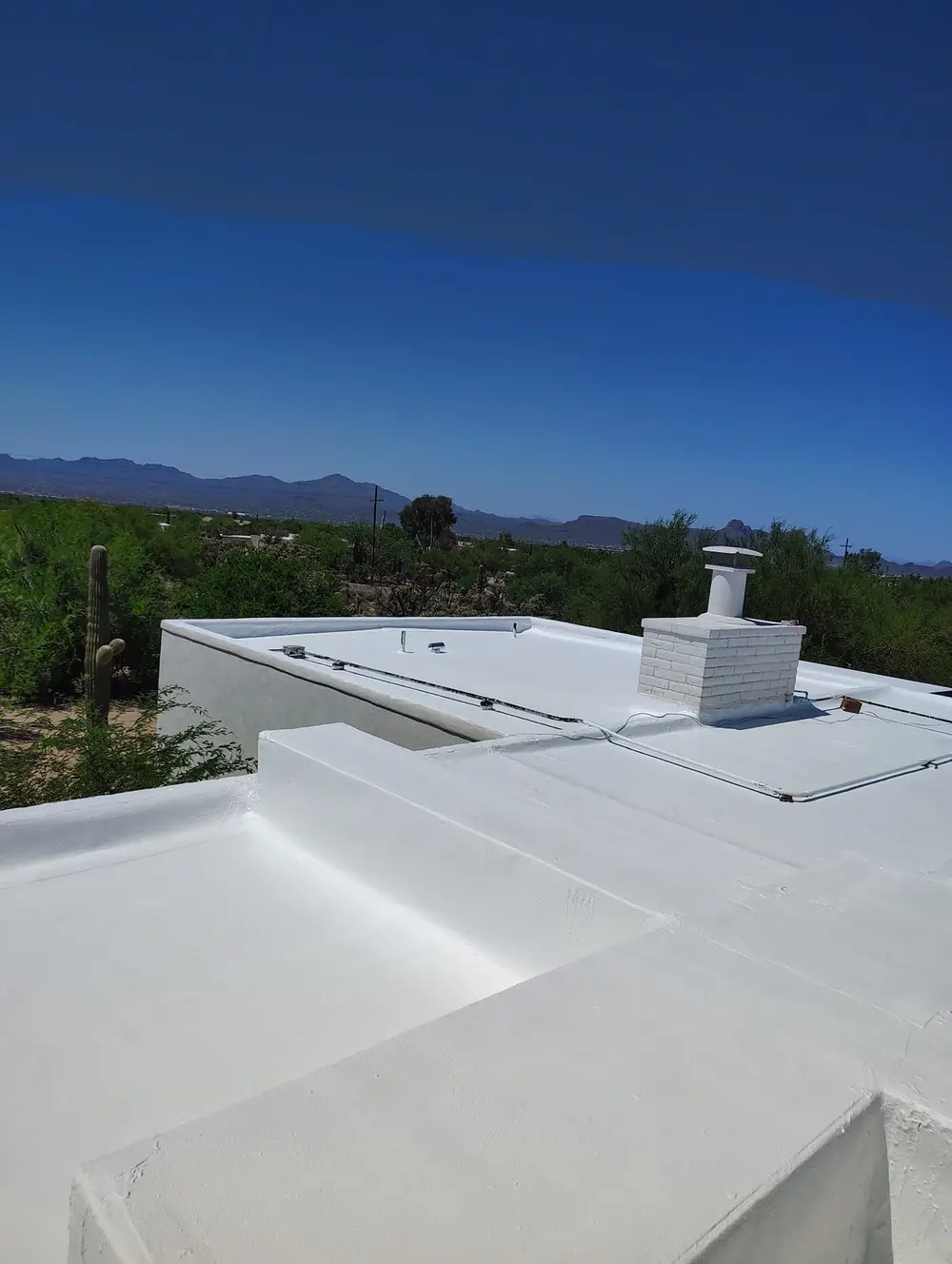 Bright white roof coating completed on a low-sloped home on Tucson's northwest side